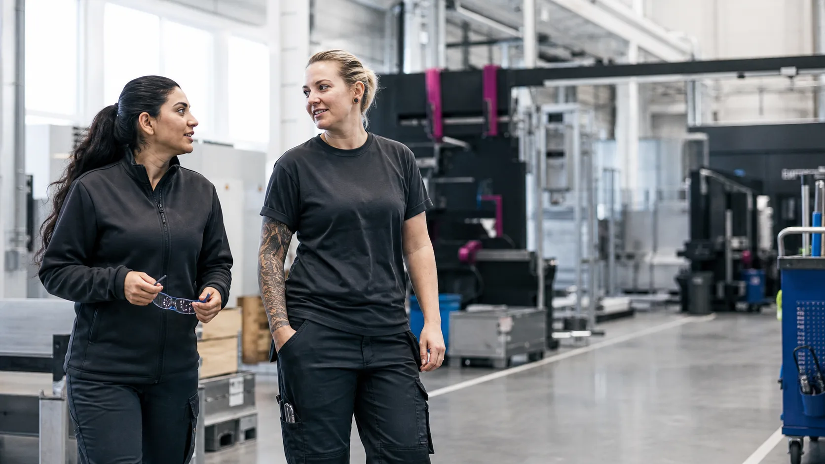 Två produktionstekniker i ett välkomnande samtal på arbetsplatsen